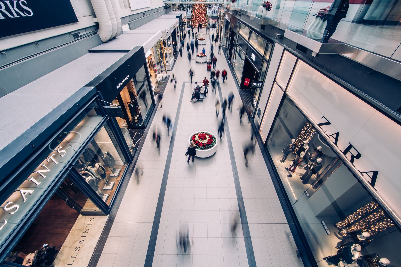 A busy multi-level shopping mall with shoppers and stores