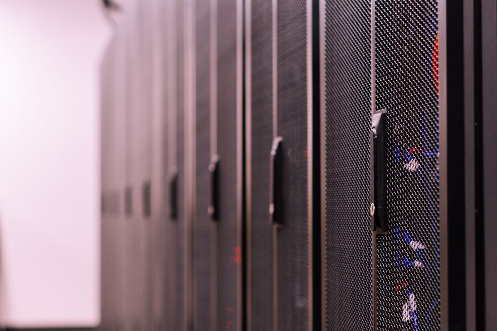 Rows of server cabinets in a data centre corridor
