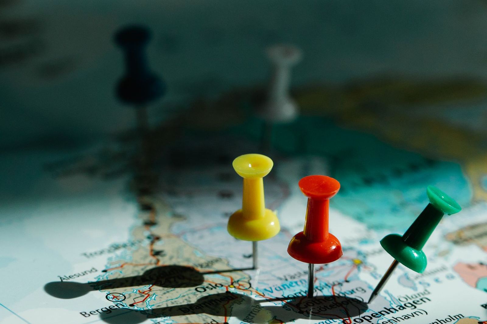 Coloured pins marking locations across a world map