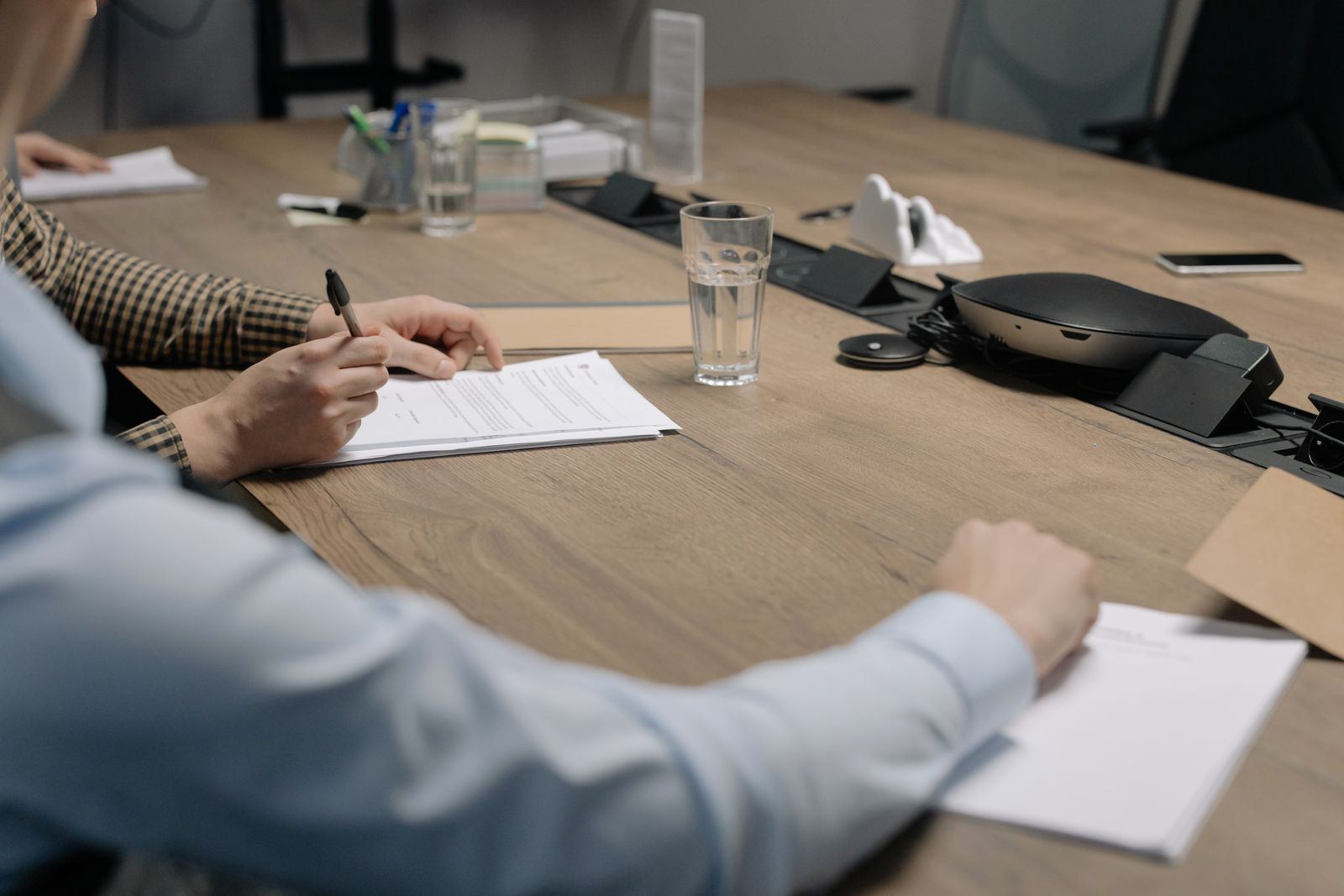 Professionals reviewing and signing documents at a meeting table