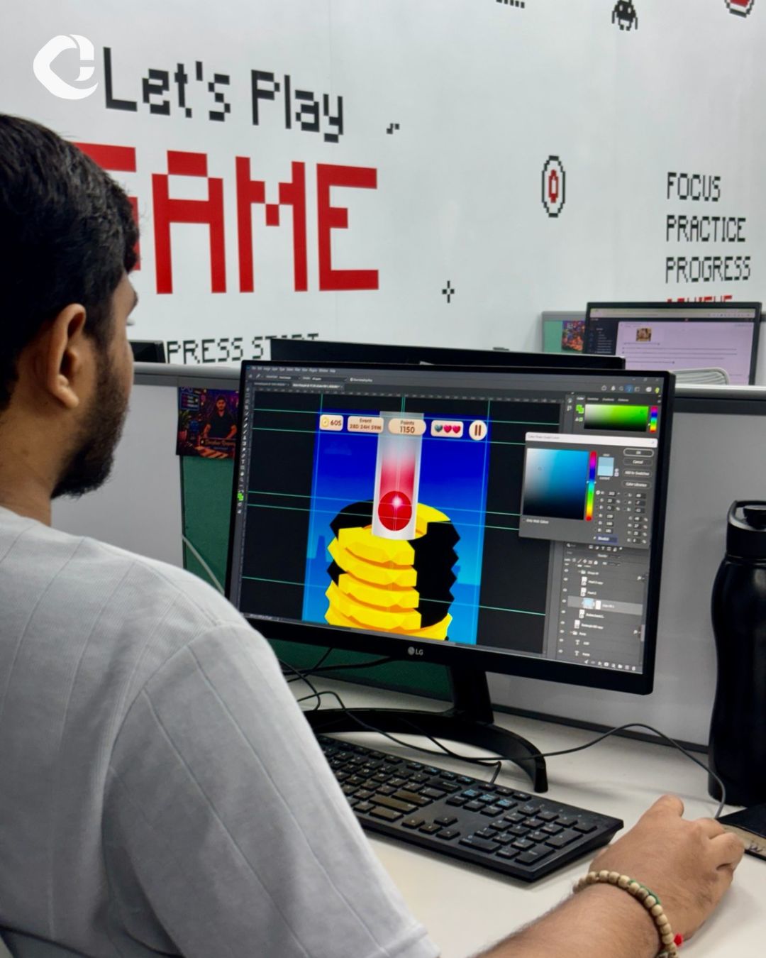 A Capermint team member designing a colorful casual puzzle game at a workstation inside the studio